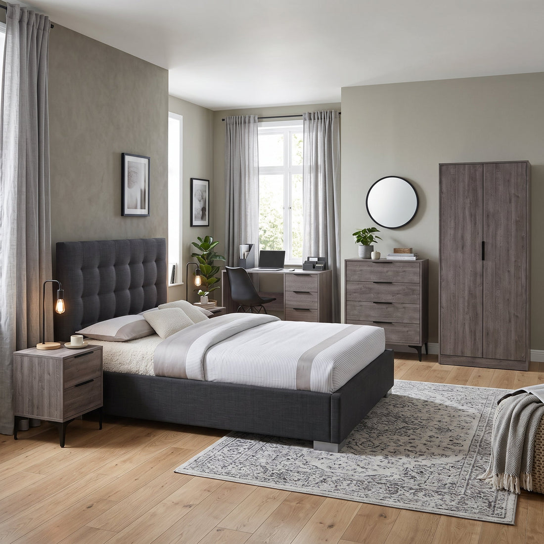 Bedroom with a grey upholstered double bed, matching wood-effect wardrobe, chest of drawers, bedside table and desk.